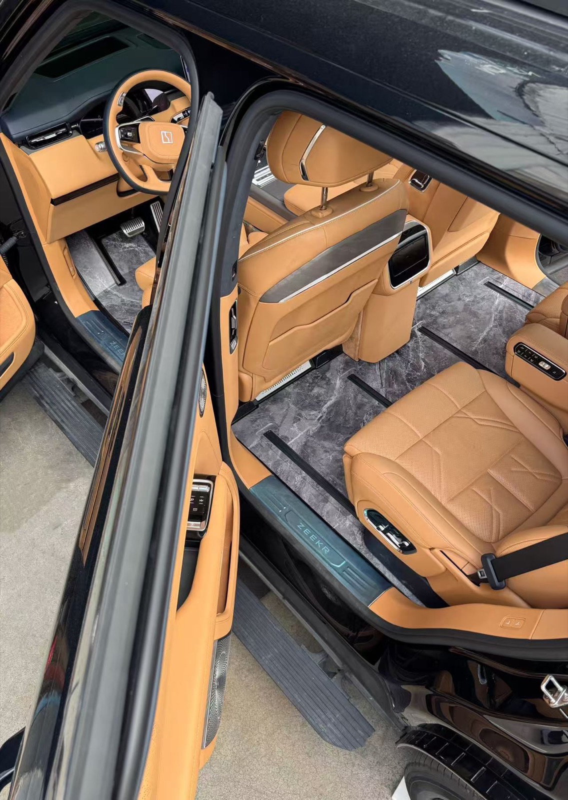 Open-door view of a complete marble grey wooden floor in a flagship SUV cabin