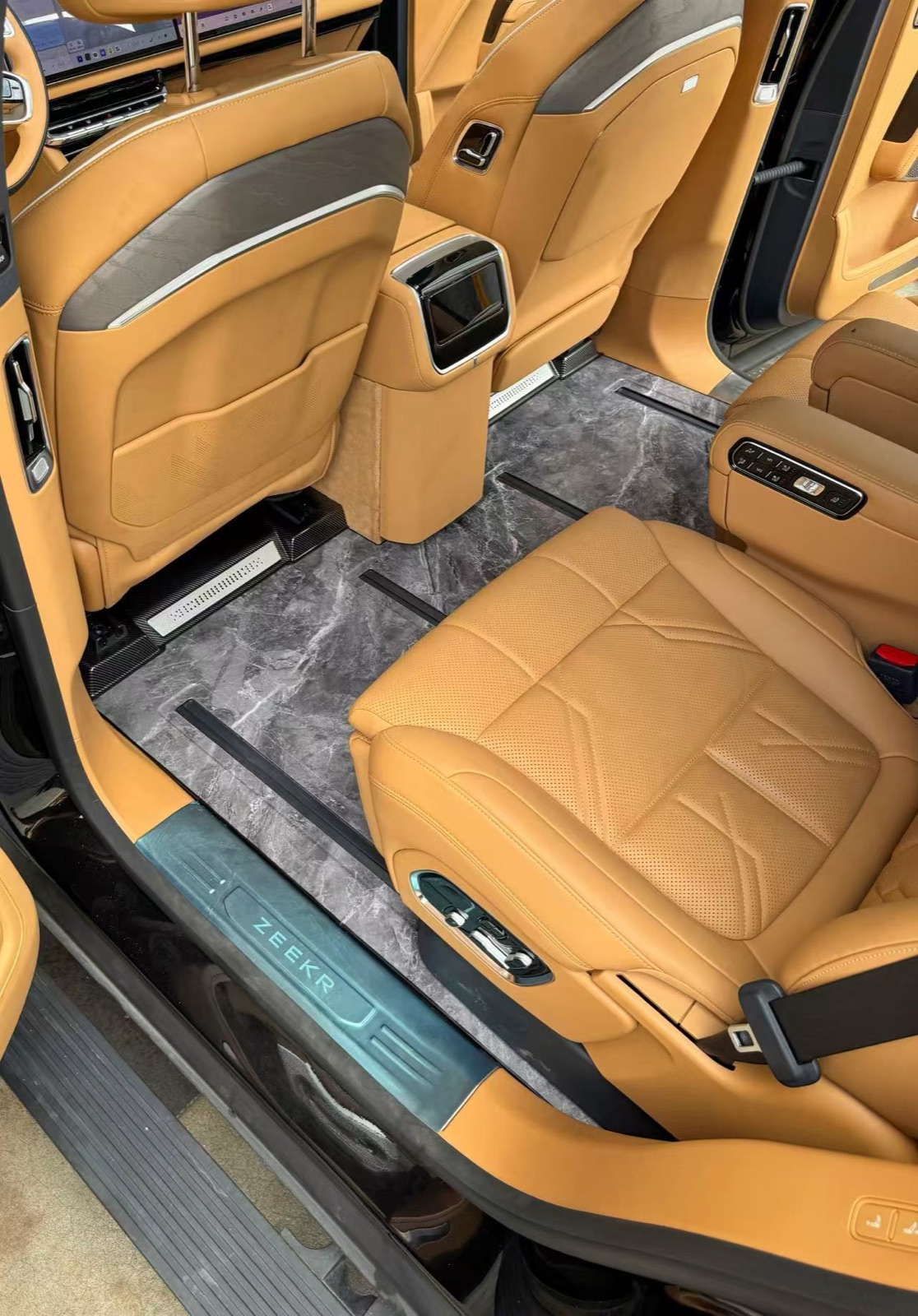 Seat rail area of a flagship SUV showing the fitted marble grey floor panels