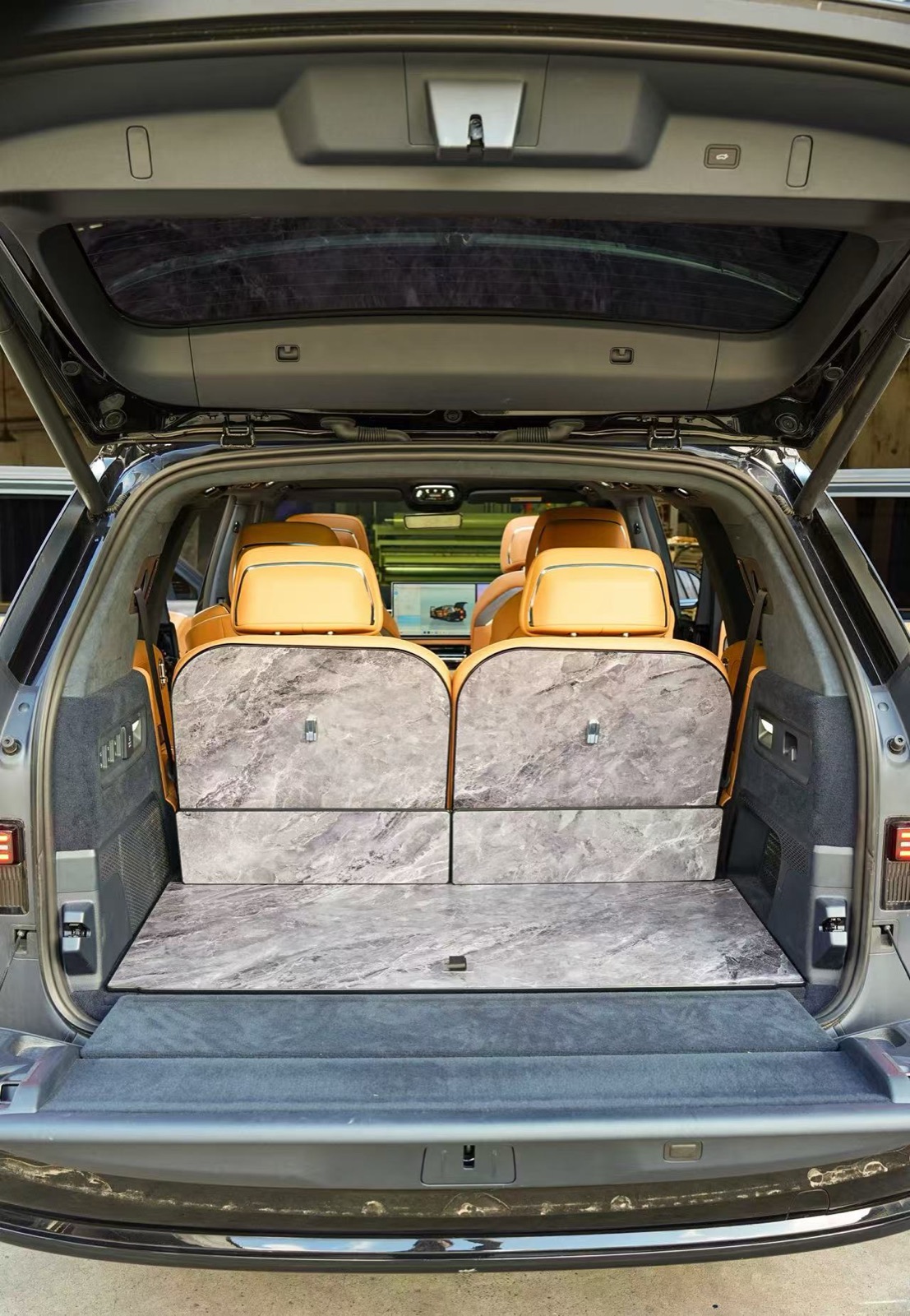 Trunk of a flagship SUV with a full marble grey floor kit and matching seat-back panels